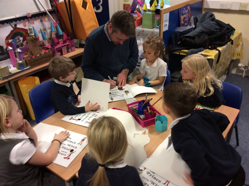 Photo of Alastair signing books with children