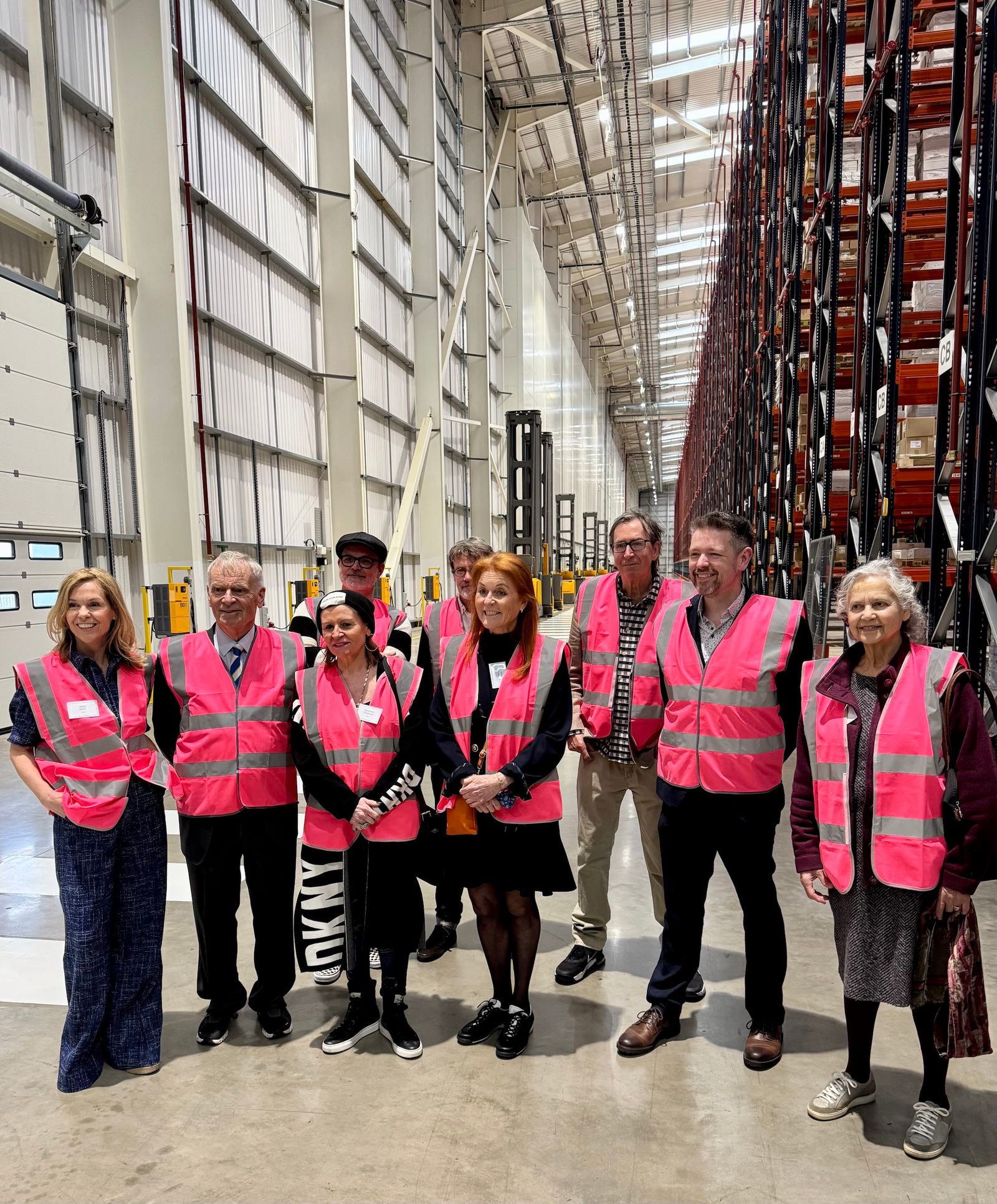 A collection of authors in pink hi-vis vests posing for their photo-op.