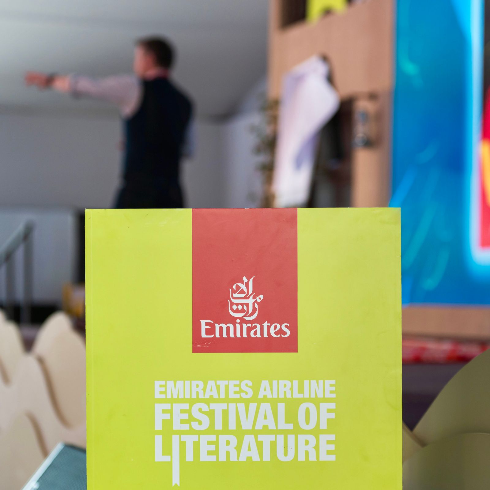 A sign saying Emirates Airline Festival of Literature, with Alastair in the background
