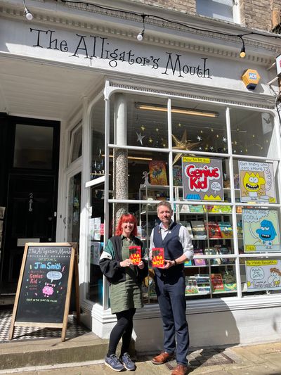 Alastair and Hannah standing in front of the shop window of The Alligator's Mouth bookshop