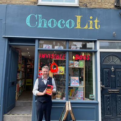 Alastair Chisholm outside Chocolit Bookshop holding a copy of his book I AM WOLF