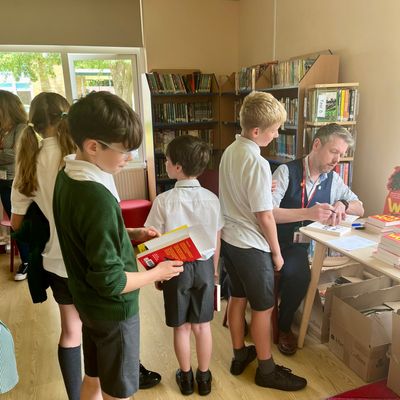 Alastair Chisholm signing books for a queue of children